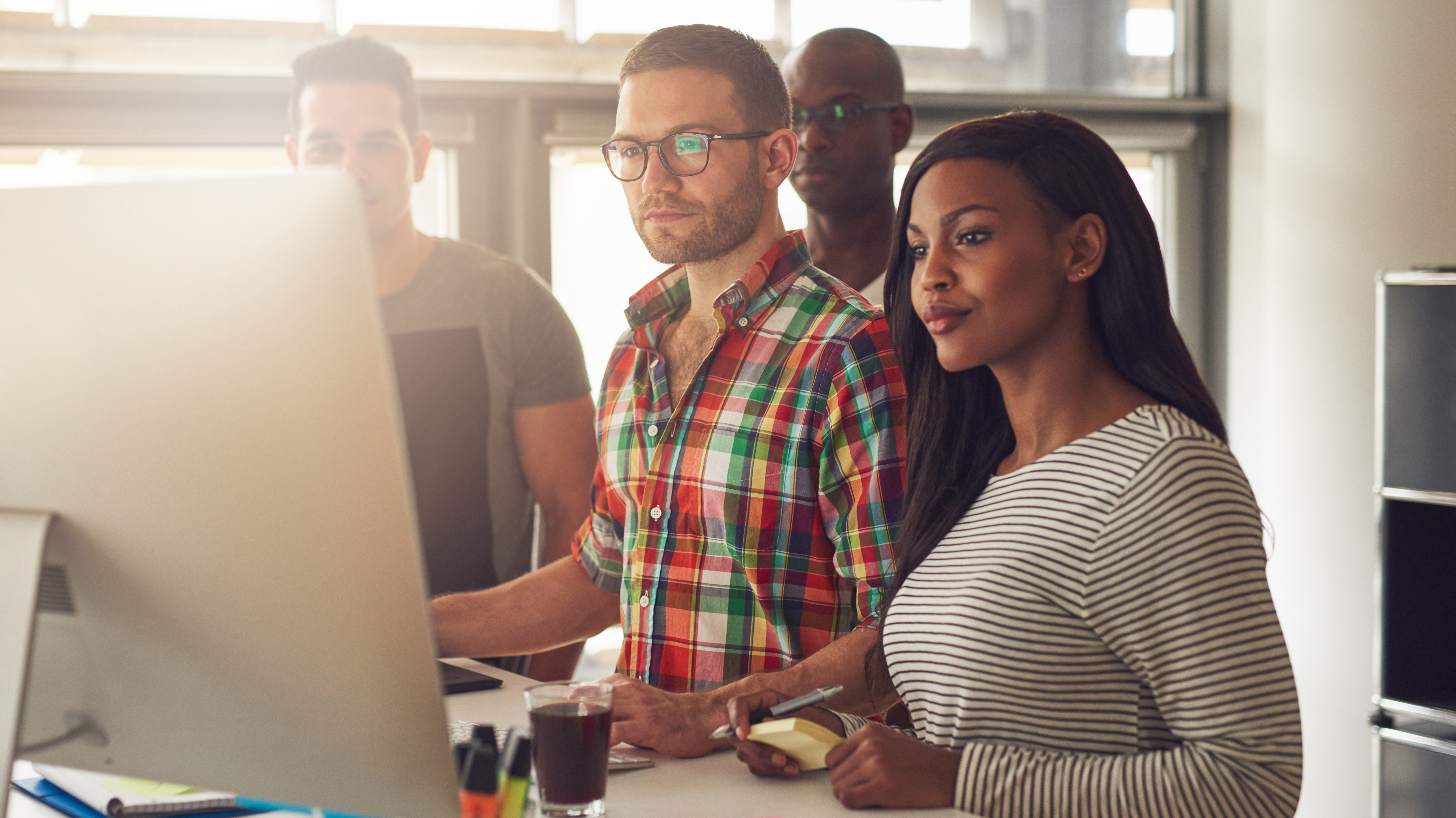 team gathered around a computer 